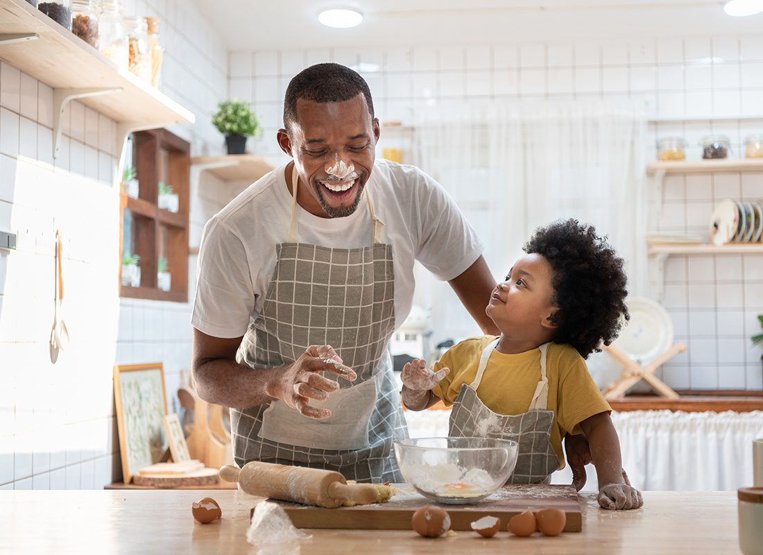 Personal Insurance - Father and Son Have Fun Together in the Kitchen Cracking Eggs and Playing With Flour